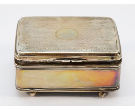 A silver lidded trinket box, Birmingham 1922, raised on four ball feet, lined interior, loaded, 9x6x4cm.