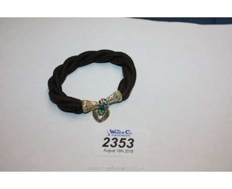 A bracelet made from woven hair with silver clasp set with turquoise and seed pearl