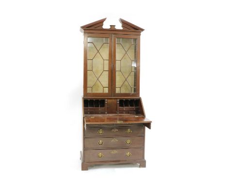 A George III mahogany bureau bookcase, with broken pediment over a pair of astragal glazed doors, the bottom section with fal