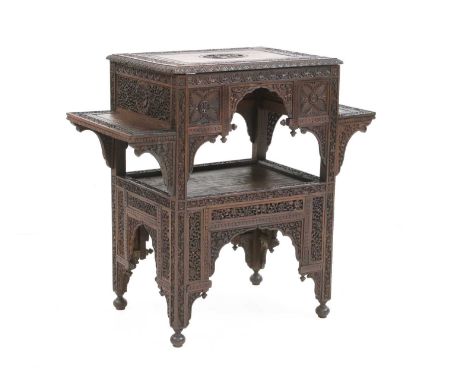 An Indian hardwood étagère, c.1890, pierced and carved in low relief with foliate designs, the top with a carved roundel of a