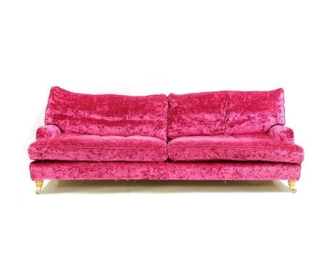 A modern three-seater Lansdowne sofa, in the manner of Howard &amp; Sons, upholstered in vibrant fuchsia crushed velvet with 
