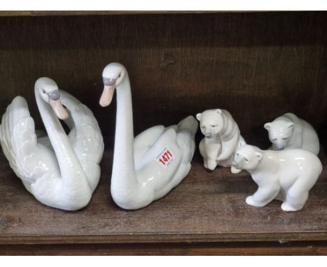 Two Lladro swans, largest 22cm high; together with three Lladro polar bears. (5)