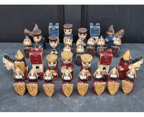 A carved and polychrome painted chess set, king 14cm high, (lacking one red bishop).