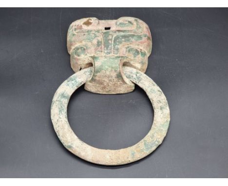Antiquities: a Chinese Archaic verdigris bronze Taotie door knocker, probably Zhou Dynasty, 25.5cm high.