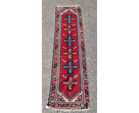 A Persian runner, having six central medallions, with geometric and floral borders.