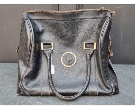 A large black leather holdall, by Gianni Versace.