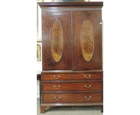 An attractive and large George III figured mahogany Linen Press, the reeded cornice with dentil moulded decoration, over two 