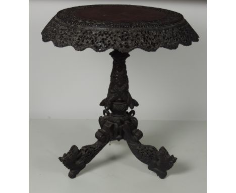 A 19th Century Anglo-Indian hardwood circular Centre Table, profusely carved with polished centre panel with carved border an