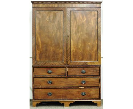 An attractive early 19th Century Irish mahogany Linen Press, the dentil moulded cornice over two doors with finely figured pa