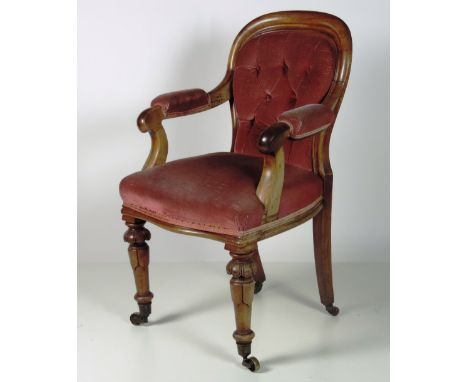 A small early 19th Century mahogany Library or Desk Chair, the oval deep buttoned back over a serpentine fronted seat, on car