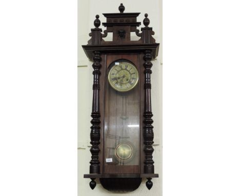 A large 19th Century Vienna Wall Clock, with circular enamel dial, and large brass pendulum, 135cms (53") high. (1)