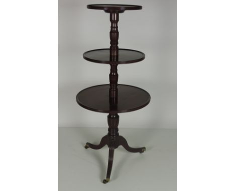 A late Georgian period circular mahogany three tier Dumbwaiter, with turned pillar supports on a tripod base with outsplayed 