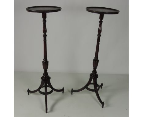 A pair of tall mahogany Torcheres or Plant Stands, with circular moulded tops on turned pillar supports and tripod bases, app