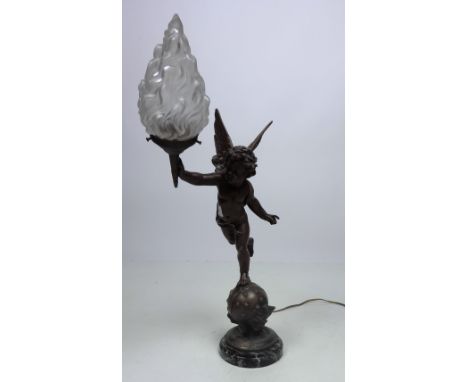 An unusual figural Table Lamp, modelled as a winged cherub, holding a flame shaped shade, on metal stand with labels, and mar