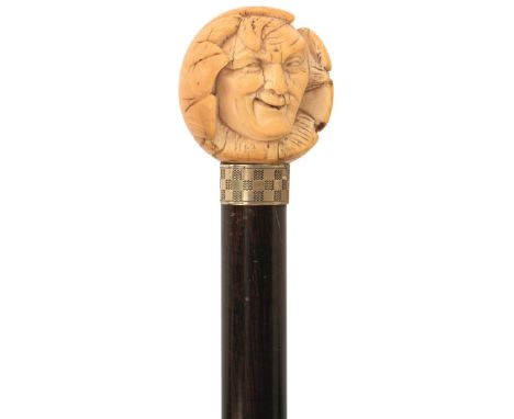 A LATE 19TH/EARLY 20TH CENTURY WALKING CANE, the spherical ivory handle carved in partial relief as the head of an elderly ge