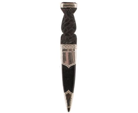 AN EARLY 20TH CENTURY SILVER MOUNTED SGIAN DUBH, 10cm fullered blade with faceted back edge, characteristic carved wooden hil