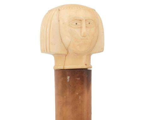 A 19TH CENTURY WALKING CANE OF SUBSTANTIAL PROPORTIONS, the ivory handle carved as a lady's head in the Egyptian revival mann