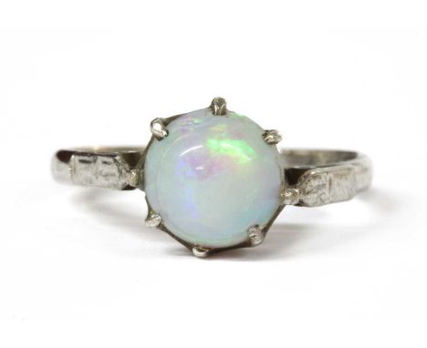 A white gold single stone opal ring, with a round cabochon opal, approximately 7.7mm diameter, claw set to tapered chenier sh