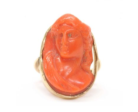 A gold carved coral cameo ring, depicting the portrait of a lady, chipped, rub set to a 'U' shaped shank, marked 8ct, tested 