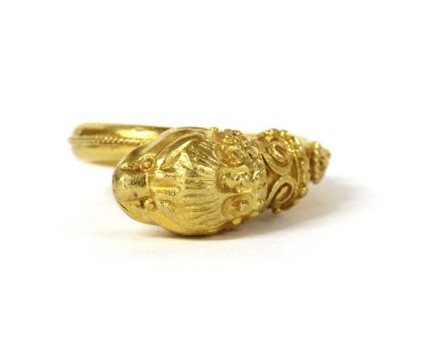 A gold Etruscan-revival style ring, with a lion head terminal, to tapering shank, tested as approximately 22ct gold, 9.59g.Fi