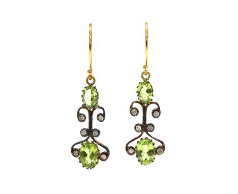 A pair of silver and gold, peridot and diamond drop earrings, an oval mixed cut peridot with a smaller peridot above, joined 