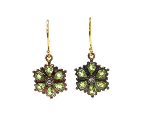 A pair of silver and gold peridot floral cluster earrings, a colourless paste to the centre, to surround of pear mixed cut pe