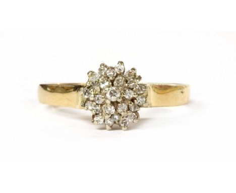 A gold diamond cluster ring, with a brilliant cut diamond claw set to the centre, to tiered rows of eight cut diamonds, all c