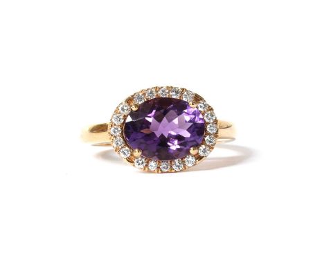 An Italian rose gold amethyst and diamond halo cluster ring, with an oval mixed cut amethyst, with a stated weight of 2.03ct,