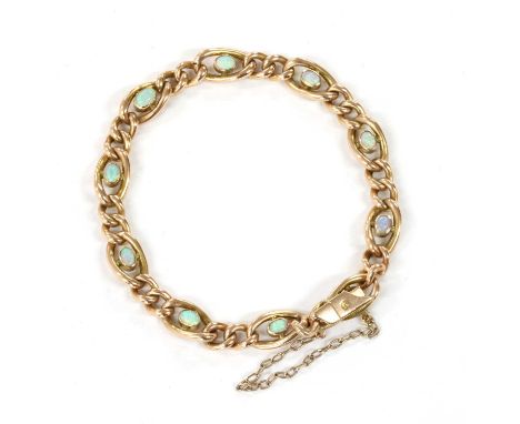 An Edwardian gold opal set curb bracelet, with opal cabochons, rub set to the centre of open hollow curb links, joined by sma