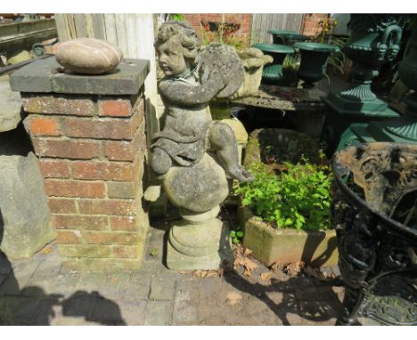 A LARGE GARDEN STONE STATUE DEPICTING A CHERUB PLAYING CYMBALS WHILST RESTING ON A STONE BALL,  H 98 cm