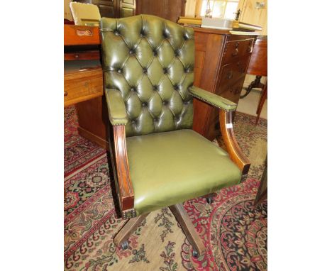 A 20TH CENTURY GREEN LEATHER SWIVEL OFFICE ARMCHAIR WITH BUTTON BACK DETAIL