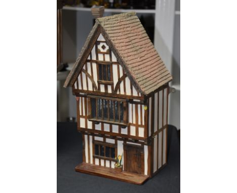 Doll's Houses - a model of a Tudor three storey town house, 24th scale, thatch effect roof above a gabled front, hinged front