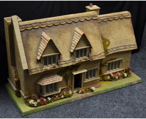 Mike Marsden, Yesteryear Homes - a  20th Century dolls house,  in the form of a thatched cottage, 105cm wide;  various dolls 