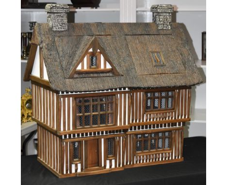 Doll's Houses - Robert Stubbs of Norfolk, a 1/12 (48th) scale model, Tudor House, thatch effect roof above a gabled front wit