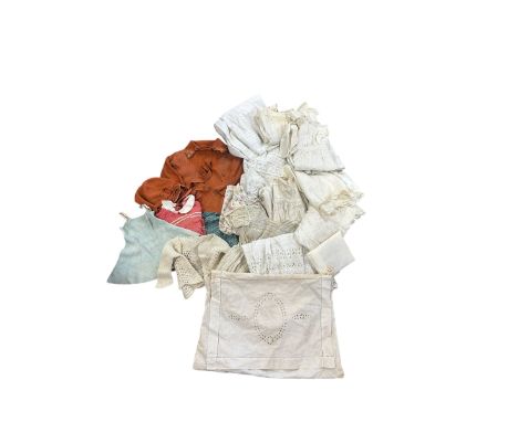 An early 20th century hand cutwork pyjama case holding a group of christening gowns, mostly in cotton and one in silk complet