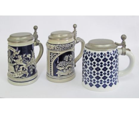 Three German ceramic beer tankards with pewter lids. Two with relief decorations and one with blue geometric designs. Late 20