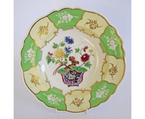 An English porcelain dish in green, yellow and gold colours, transfer print and over painted in the Chinese taste. Marked wit