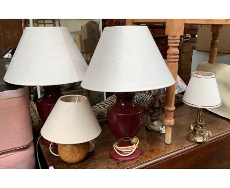 A pair of aubergine ceramic baluster lamps with shades, overall height 56cm; together with three others 
