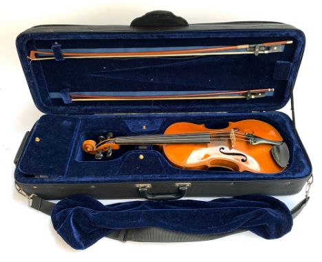 A full size violin in hard rectangular case, marked 'Manufactured in Dresden', with two bows and various accessories 