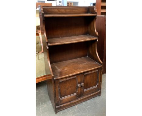 An Ercol oak waterfall bookcase, with cupboard below, 61cmW 