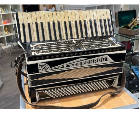 A vintage 'Coronado' 120 bass accordion, black with jeweled detail and pealescent keys, with sheet music 