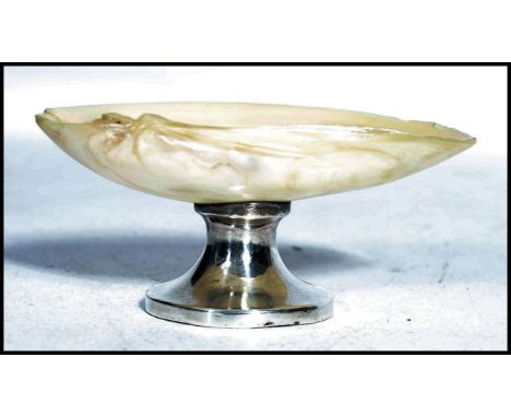 A silver hallmarked and mother of pearl table salt raised on a circular silver base with mother of pearl shell bowl top. Hall