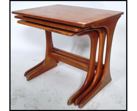 A set of three vintage 20th century Danish influence teak nest of tables in the manner of G-Plan. The panel tops raised on sp