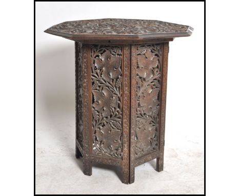 A 19th century black forest carved oak folding table of Octagonal form having carved leaf design to the top with stunning pie