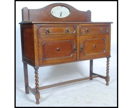 A 1920's oak barleytwist / barley twist mirror back sideboard dresser base. Raised on barley twist legs united by stretchers 