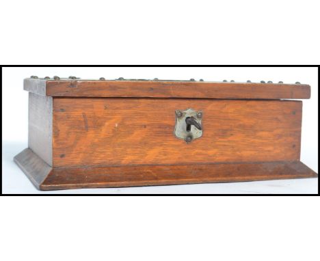 A 1920's oak table lidded cigarette box of rectangular form having pressed metal decoration and a brass emblem for ' cigarett