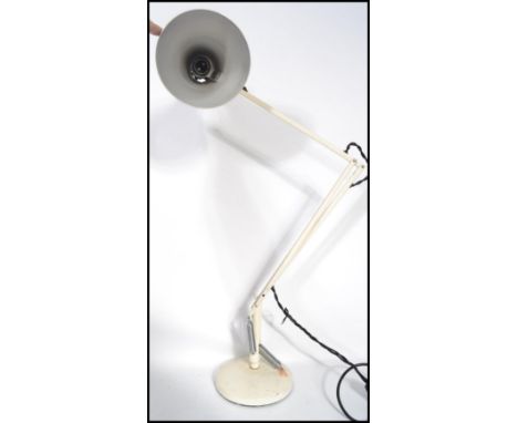 A vintage retro 20th century industrial anglepoise desk lamp raised on a circular base with pendant shade.