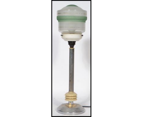 An early 20th century art deco table lamp having a column and bulbous gilt bottom on a terraced base with a spherical frosted