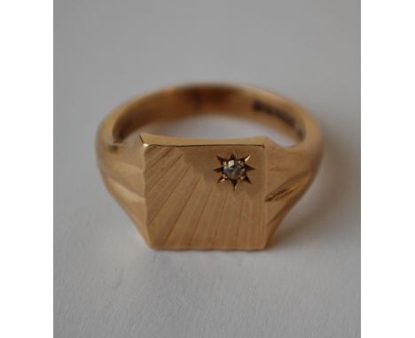 A hallmarked 9ct gold signet ring with sunburst face having a star set diamond. Hallmarked Birmingham. Size R. Weight 6.8g.
