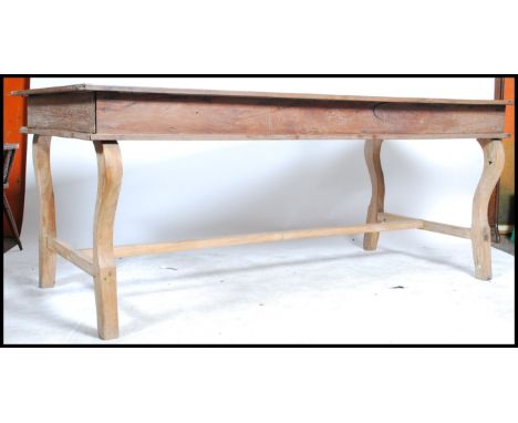 A large 20th century Hardwood refectory dining table in the French style. Raised on shaped legs with a fitted frieze having a